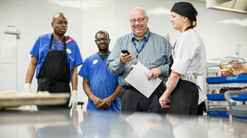 Four Sodexo employees having a meeting in a kitchen